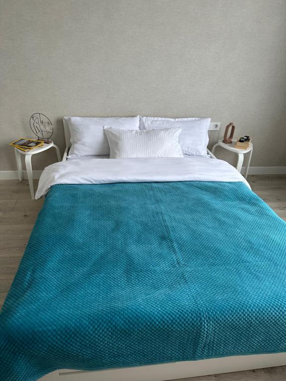 a large bed with a blue blanket on it at Комфортно, как дома in Astana