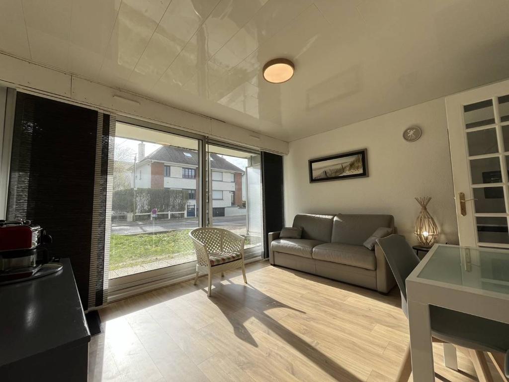 un salon avec un canapé et une table dans l'établissement TourvilleA01, à Le Touquet-Paris-Plage