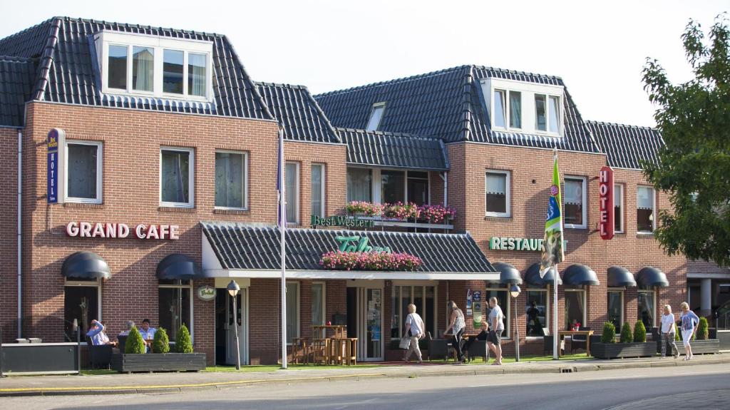 een groep mensen die buiten een groot café staan bij Hotel Restaurant Talens Coevorden in Coevorden