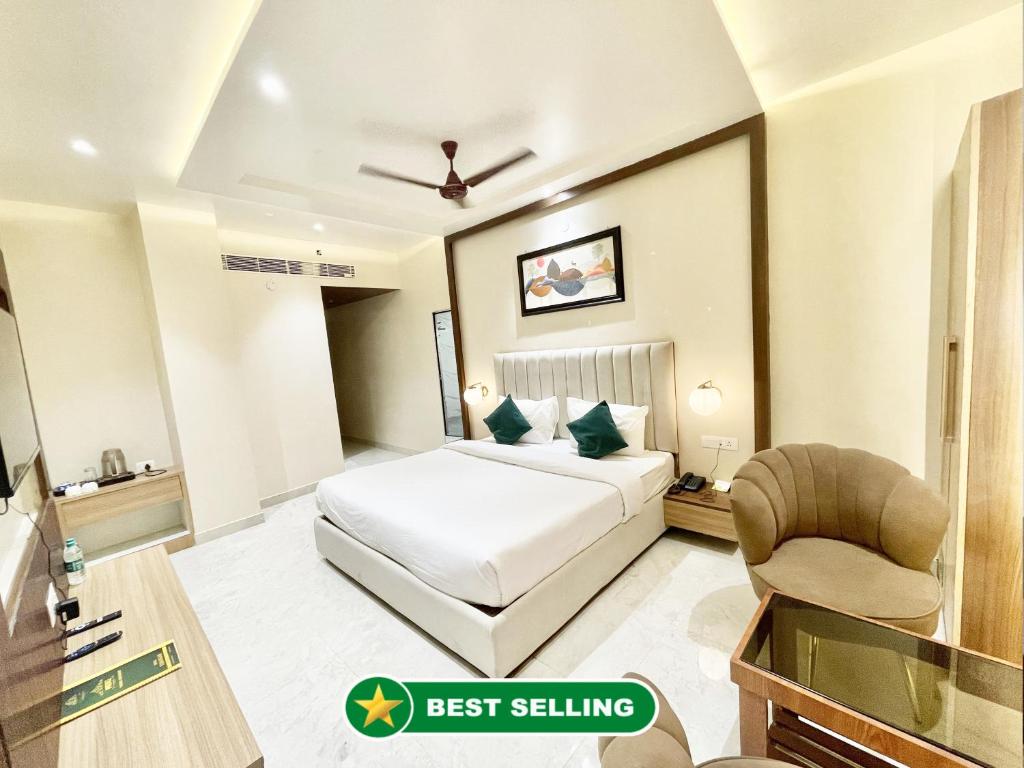 バラナシにあるHOTEL VEDANGAM INN ! VARANASI - Forɘigner's Choice ! fully Air-Conditioned hotel with Parking availability, near Kashi Vishwanath Temple, and Ganga ghatのベッドと椅子付きのホテルルーム