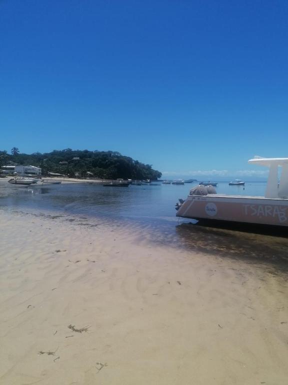 a boat sitting on the shore of a beach at Studios Léa in Nosy Be