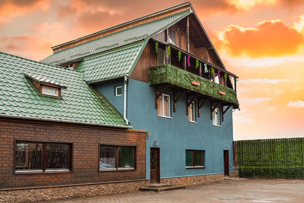 a house with a green roof with a balcony at Casa Rosu in Cluj-Napoca