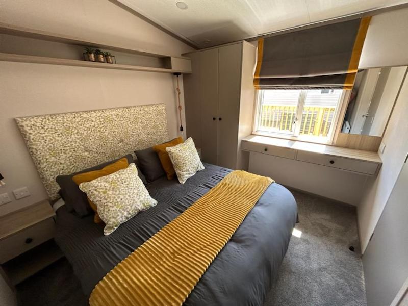 a bedroom with a bed in a small room at Luxury Hot Tub Lodge 5 Star Country Park Huge Veranda Colour Change Hot Tub Private Fishing FREE Parking in Malton