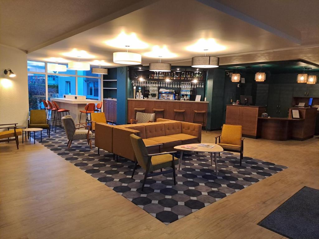 a restaurant with tables and chairs and a bar at Le Carline, Sure Hotel Collection by Best Western in Caen