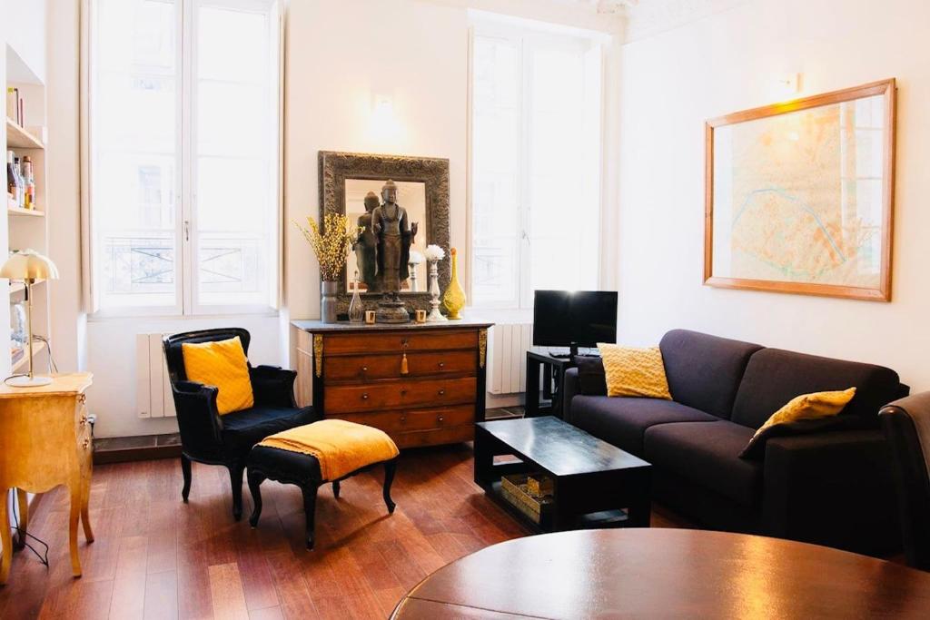 un salon avec un canapé, des chaises et une table dans l'établissement Romantic Apartment near Le Marais, à Paris
