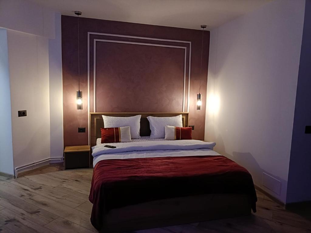 a bedroom with a large bed with a large headboard at Central Train Station Apartment in Braşov