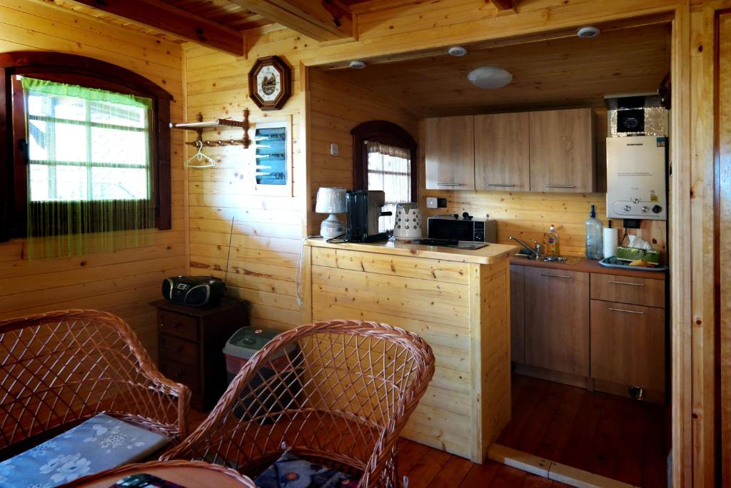 a small kitchen with two chairs in a cabin at Bajkowa dolina in Niegowa