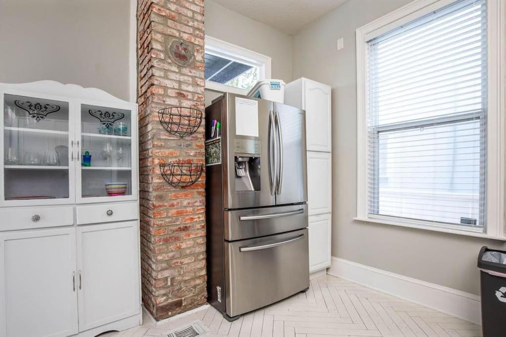 a kitchen with a refrigerator and a brick wall at Historic 3 Bedroom Home in Jacksonville