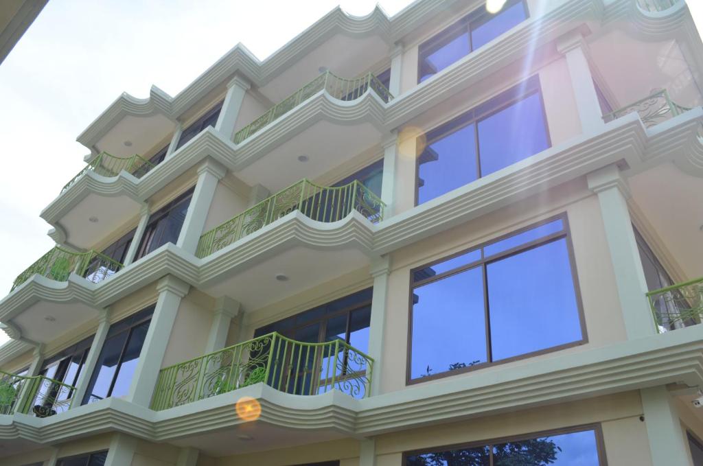 Großes weißes Gebäude mit Balkon in der Unterkunft Luxury Budget Hotels in Arusha