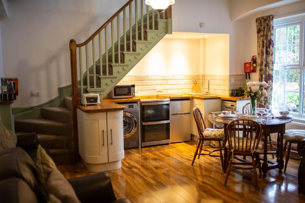 una cocina con escalera, mesa y sillas en Seymour Johnston, en Johnston