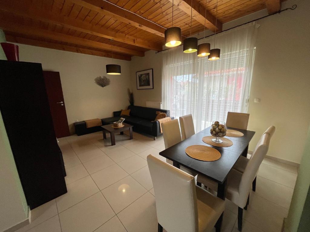 a dining room with a table and chairs and a couch at House Hévíz in Hévíz