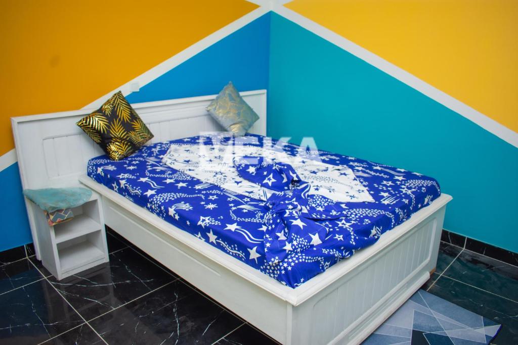 ein Bett mit einer blauen und weißen Bettdecke und Kissen in der Unterkunft Studio moderne in Pointe-Noire