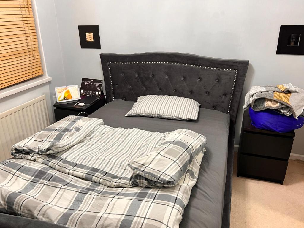 a bed with a black headboard in a bedroom at Five Newcastle Town House in Kenton