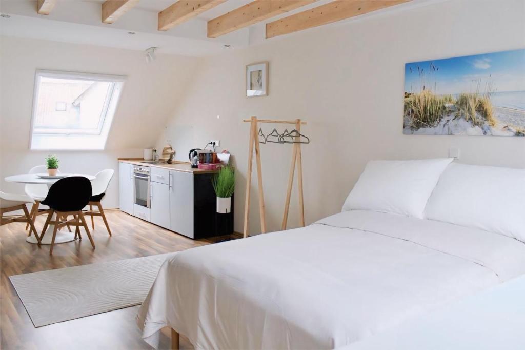 a white bedroom with a white bed and a table at Traumhaftes 1-Zimmer Appartement in Roxheim