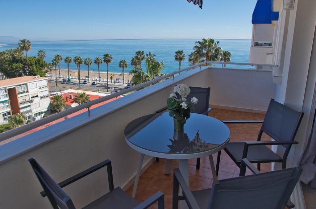 balcón con mesa, sillas y vistas al océano en Apartamento, Sol y Playas, en Benalmádena