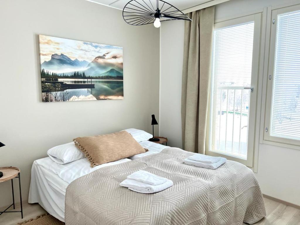 um quarto com uma cama com duas toalhas em Kotimaailma Apartments Tervapääsky I em Oulu