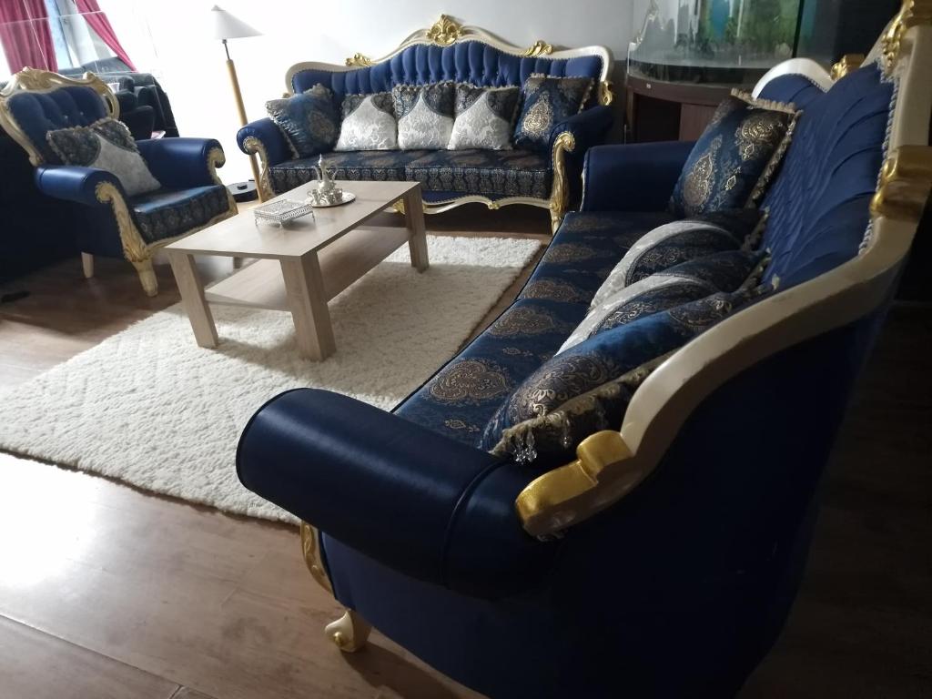 Sala de estar con sofás azules y mesa de centro en Deluxe suite, en Malmö