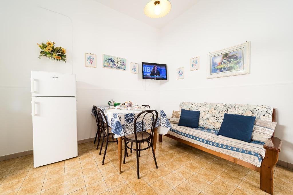 ein Esszimmer mit Tisch und Couch in der Unterkunft Casa Silvia By Vivimy in Taviano