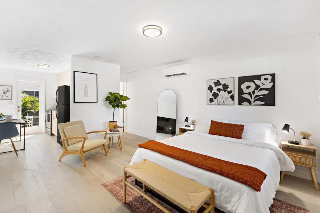 a white bedroom with a large bed and a desk at Lovely Rental Unit with free Parking on Premises in Fort Lauderdale