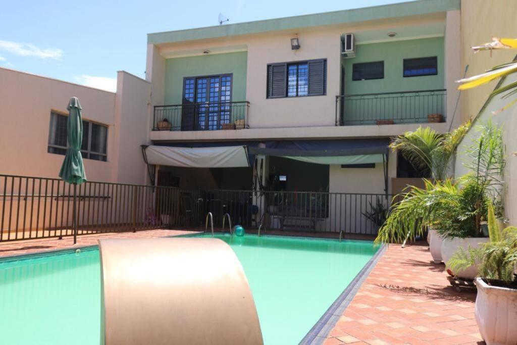 a swimming pool in front of a house at Lindo Sobrado Bandeirantes 4 quartos in Ribeirão Preto