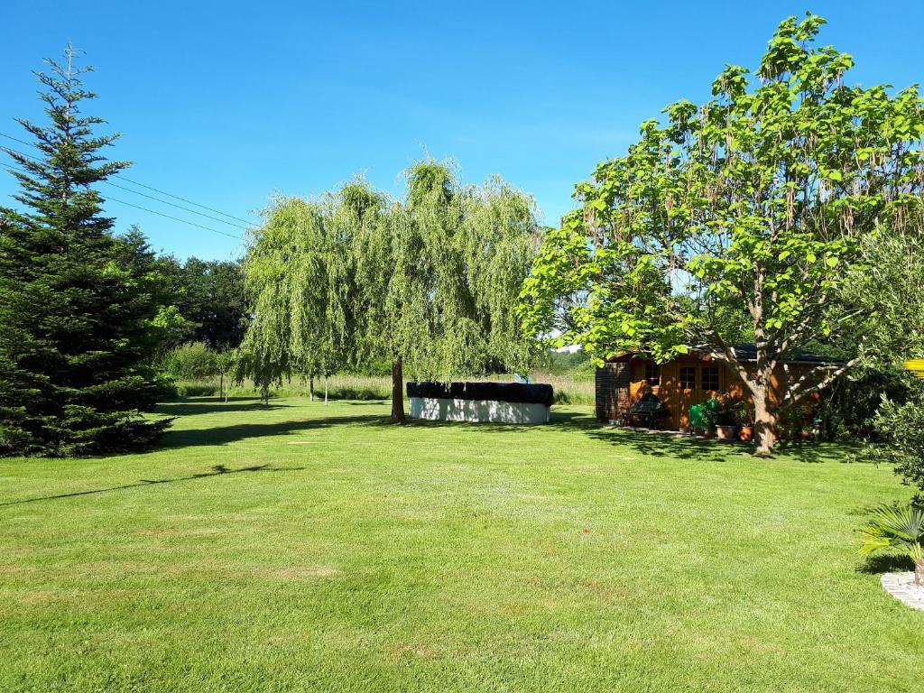 a green yard with a tree and a fence at Le chaudron vert in Moncé-en-Belin