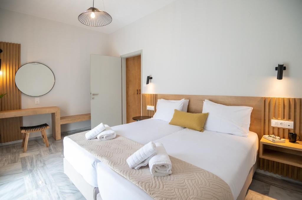 a bedroom with a large white bed with towels on it at Mardinik Hotel Apartments in Rethymno
