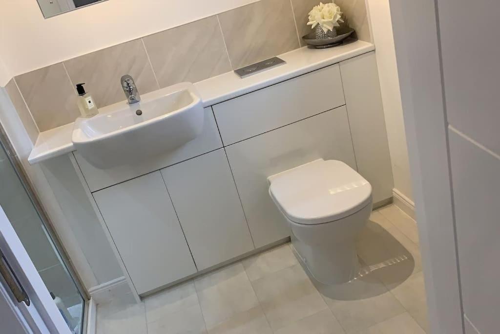 Baño blanco con lavabo y aseo en 3 bedroom detached house, en Cononbridge