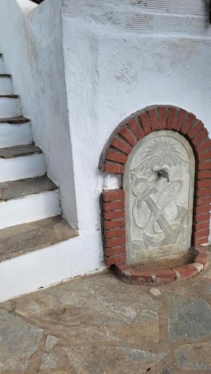 a brick door in a wall next to a staircase at Eirini Home in Andros