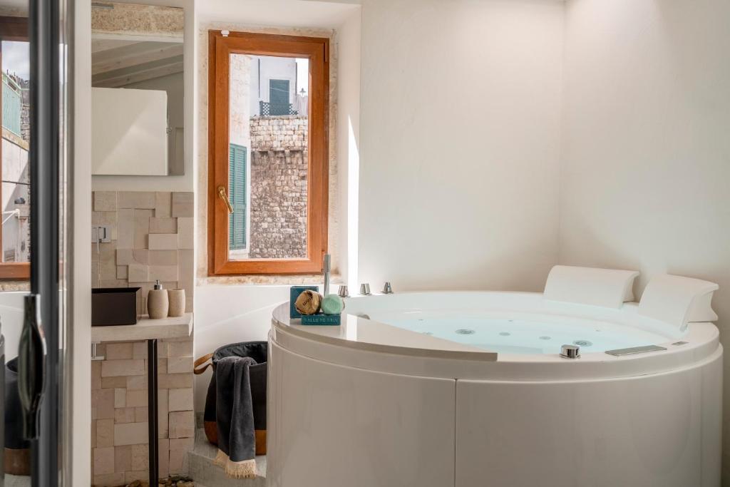 a bath tub in a bathroom with a window at Massaroom a Corte in Conversano