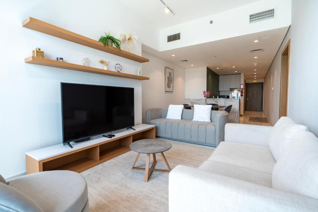 a living room with a television and a couch at Appartement Dubai in Dubai