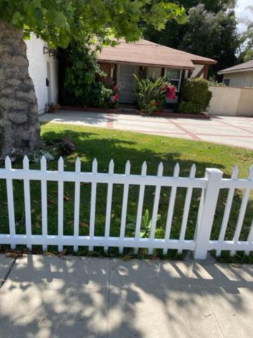 una cerca blanca frente a una casa en Orchard house en Los Ángeles
