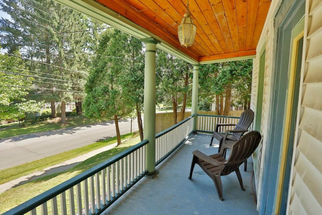 a porch with two chairs and a wooden roof at The Hill All Star Baseball Rentals in Oneonta