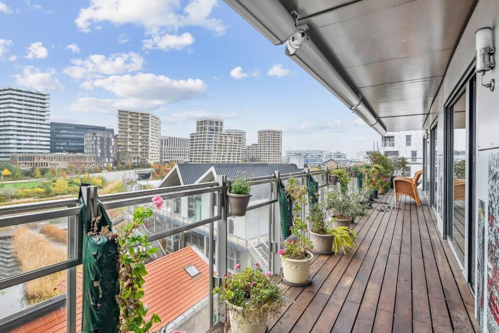 a balcony with potted plants and a view of the city at Magnifique appartement sur parc in Paris