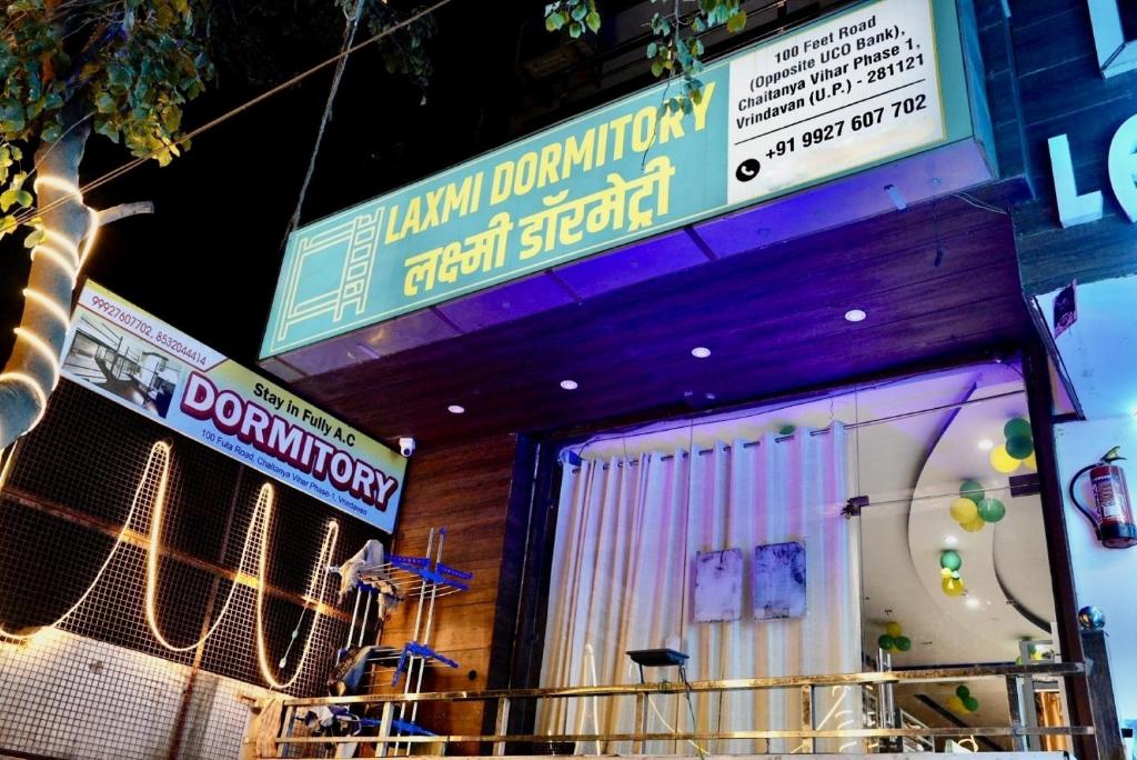 una tienda con letreros al lado de un edificio en Laxmi Dormitory en Vrindāvan