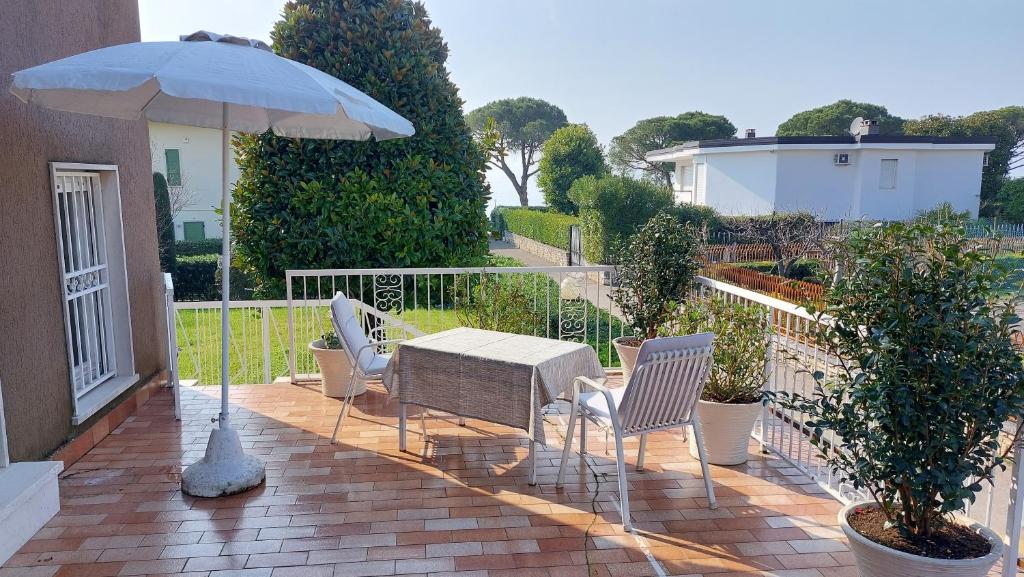 a patio with a table and chairs and an umbrella at Verbena Holiday Apartment in Lazise
