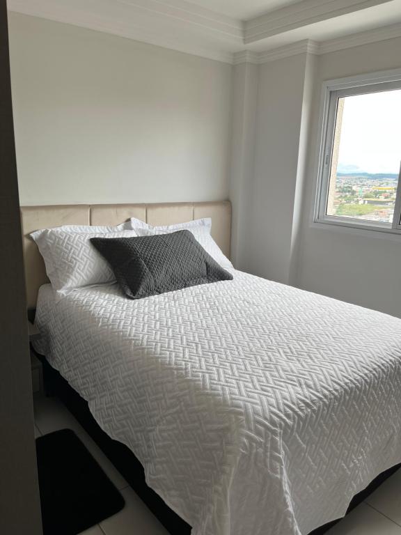 A bed or beds in a room at Apartamento novo no centro de Guarapuava - PR