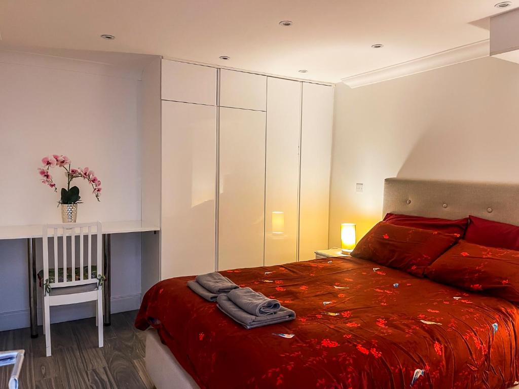 a bedroom with a bed with a red blanket at Ensuite Room with Jacuzzi in London