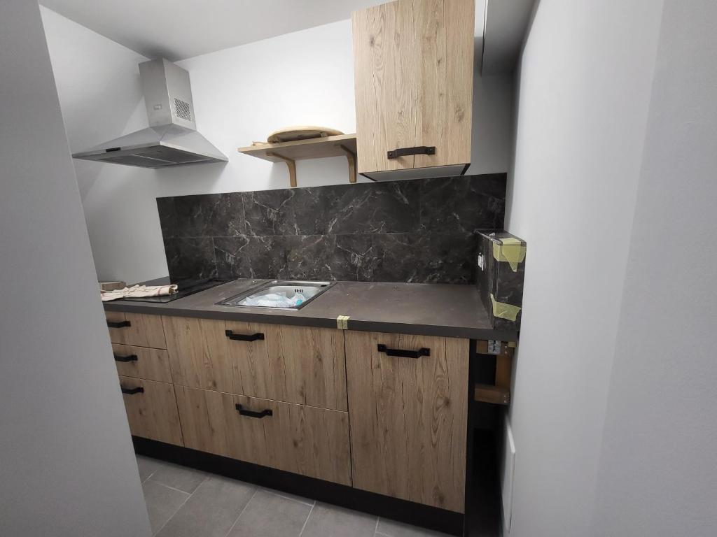 eine Küche mit Holzschränken und einer Arbeitsplatte in der Unterkunft Casa Labirinto vakantie-appartementen in Barna