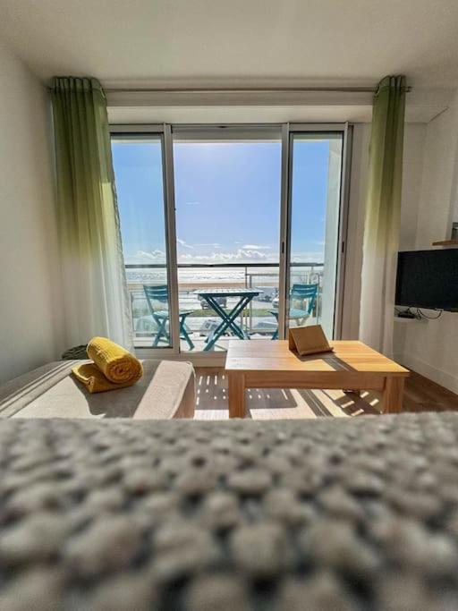 Cette chambre comprend un lit et une grande fenêtre avec vue. dans l'établissement Vue mer - accès plage direct, à Saint-Jean-de-Monts