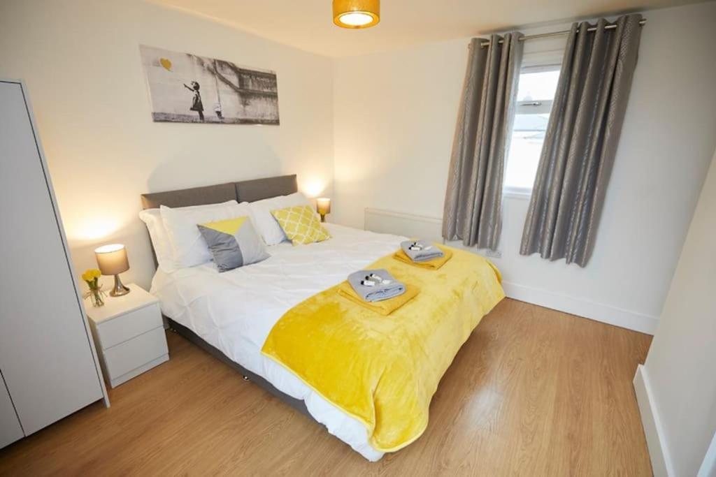 a bedroom with a bed with a yellow blanket on it at Great 2 Bedroom Apartment 6 Shirley Area SO15 Sleeps 6 in Southampton
