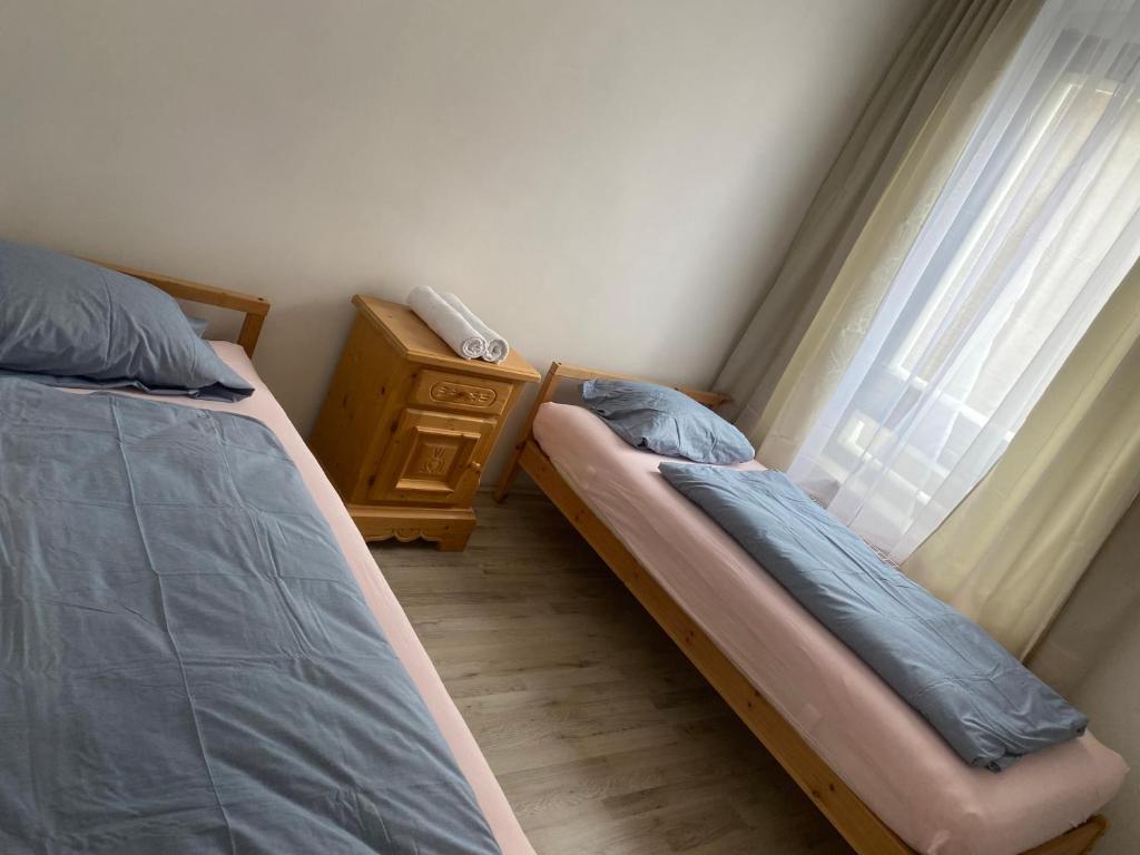 een slaapkamer met 2 bedden, een dressoir en een raam bij Apartment OB in Oberhausen