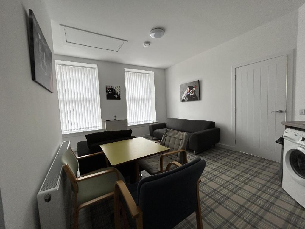 a living room with a table and a couch at Buckie Haven 3 Bed Contractors Business Travellers in Buckie
