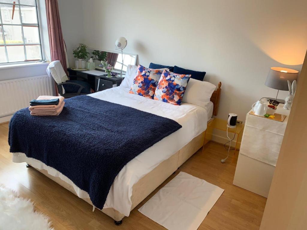 um quarto com uma cama grande e um cobertor azul em Big bright room em Carrigaline
