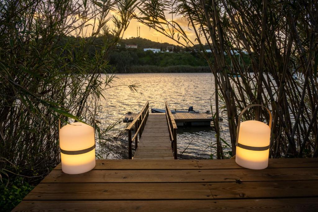 een houten dock met twee lichten op het water bij Apartamento para pareja, Finca Contrabando. Sanlucar del Guadiana in Sanlúcar de Guadiana