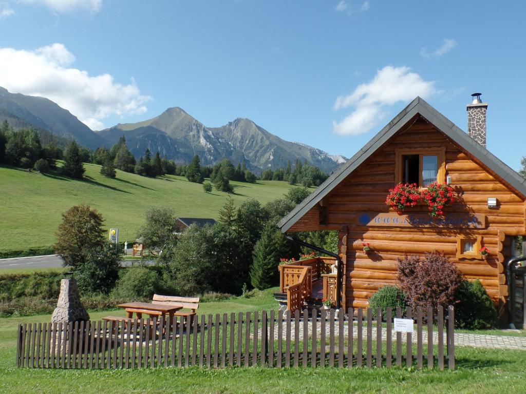 a log cabin with a table and a fence at Chata pod Belianskymi Tatrami in Ždiar