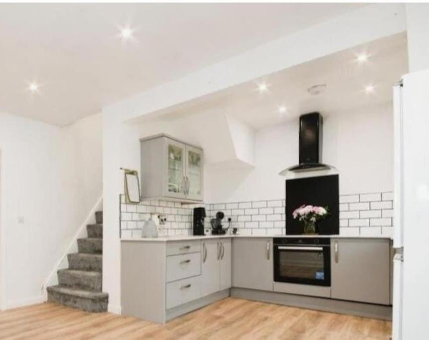 a kitchen with white walls and a staircase at Spacious and homely House in Nottingham