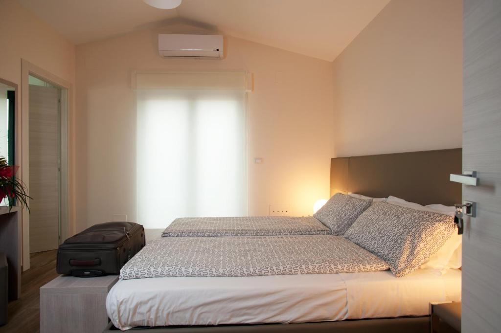 a bedroom with a bed with a suitcase and a window at B&B Raffaello a Mare in Montesilvano