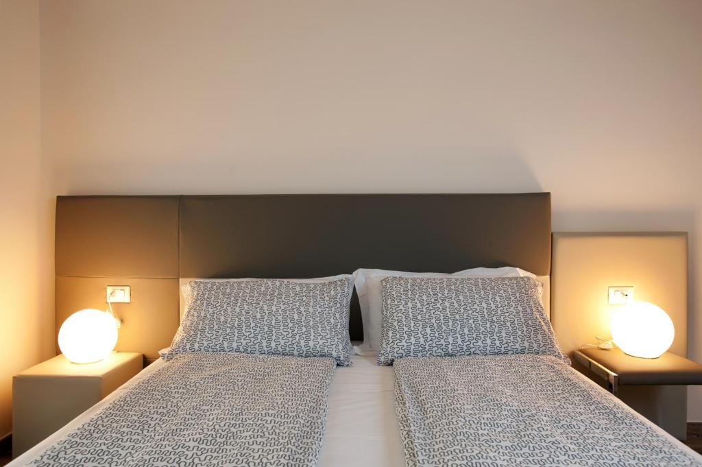 a bedroom with a bed with two pillows and two lamps at B&B Raffaello a Mare in Montesilvano
