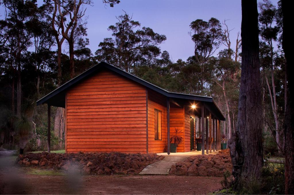a wooden cabin in the woods at night at Island Brook Estate Winery and Chalets in Metricup