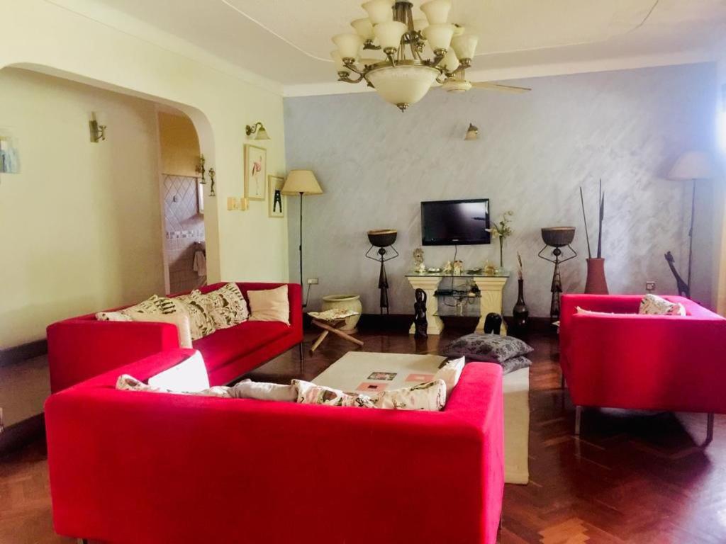sala de estar con 2 sofás rojos y TV en Nieta Chunu, en Dar es Salaam